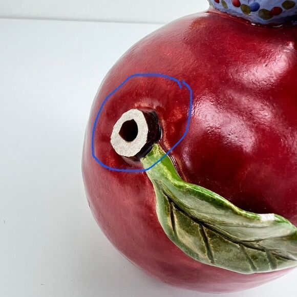 CARRIANNE L HENDRICKSON woman with beak hat sitting on apple sculpture 2… - Picture 12 of 16